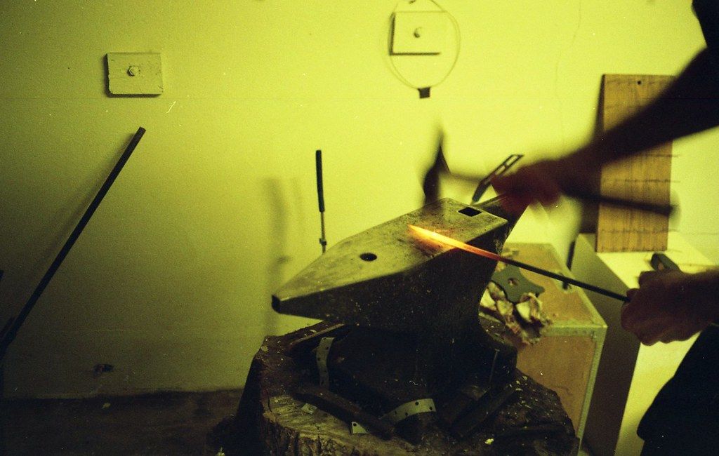 A Blacksmith Pounds Hot Metal On An Anvil At Smedjan Sweden