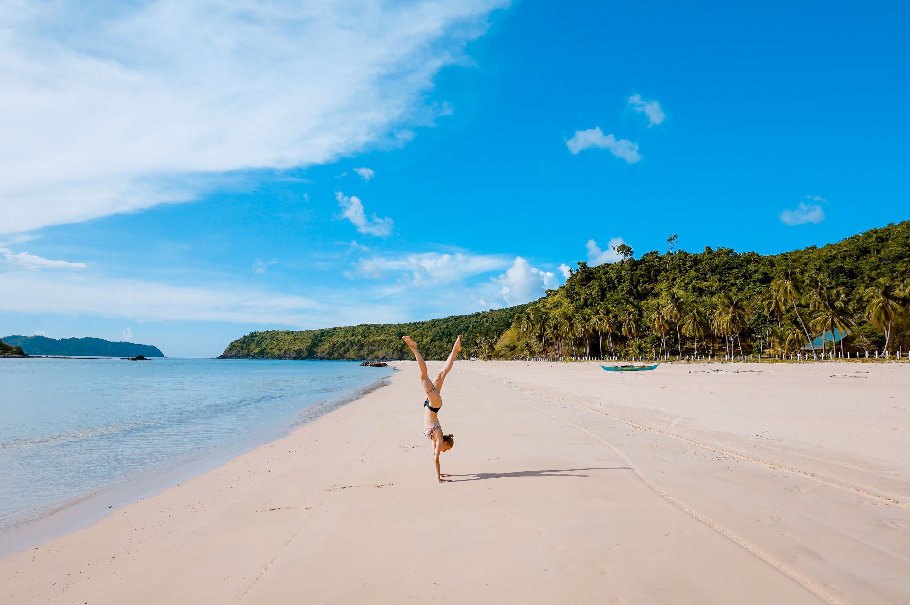 Woman doing beach acrobatics in Palawan, Philippines