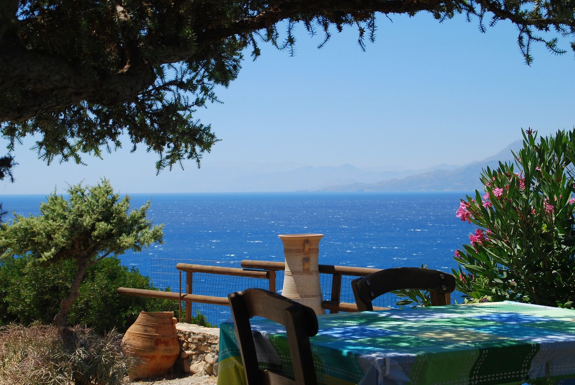 Ocean view, Crete, Greece, with a table and green trees