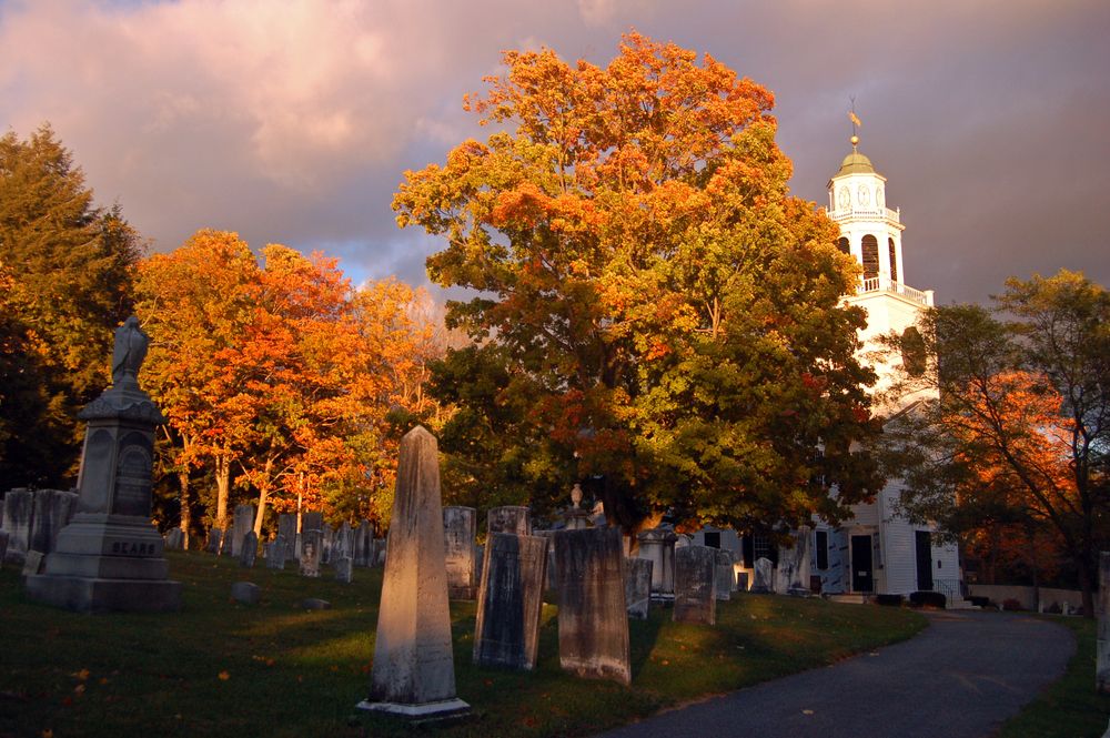 Fall colors surround a church and cemetery in Lenox, Massachusetts, USA