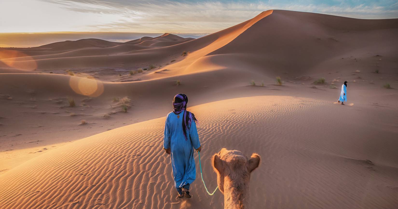 Tuareg nomads leading a camel in the Sahara Desert, Morocco