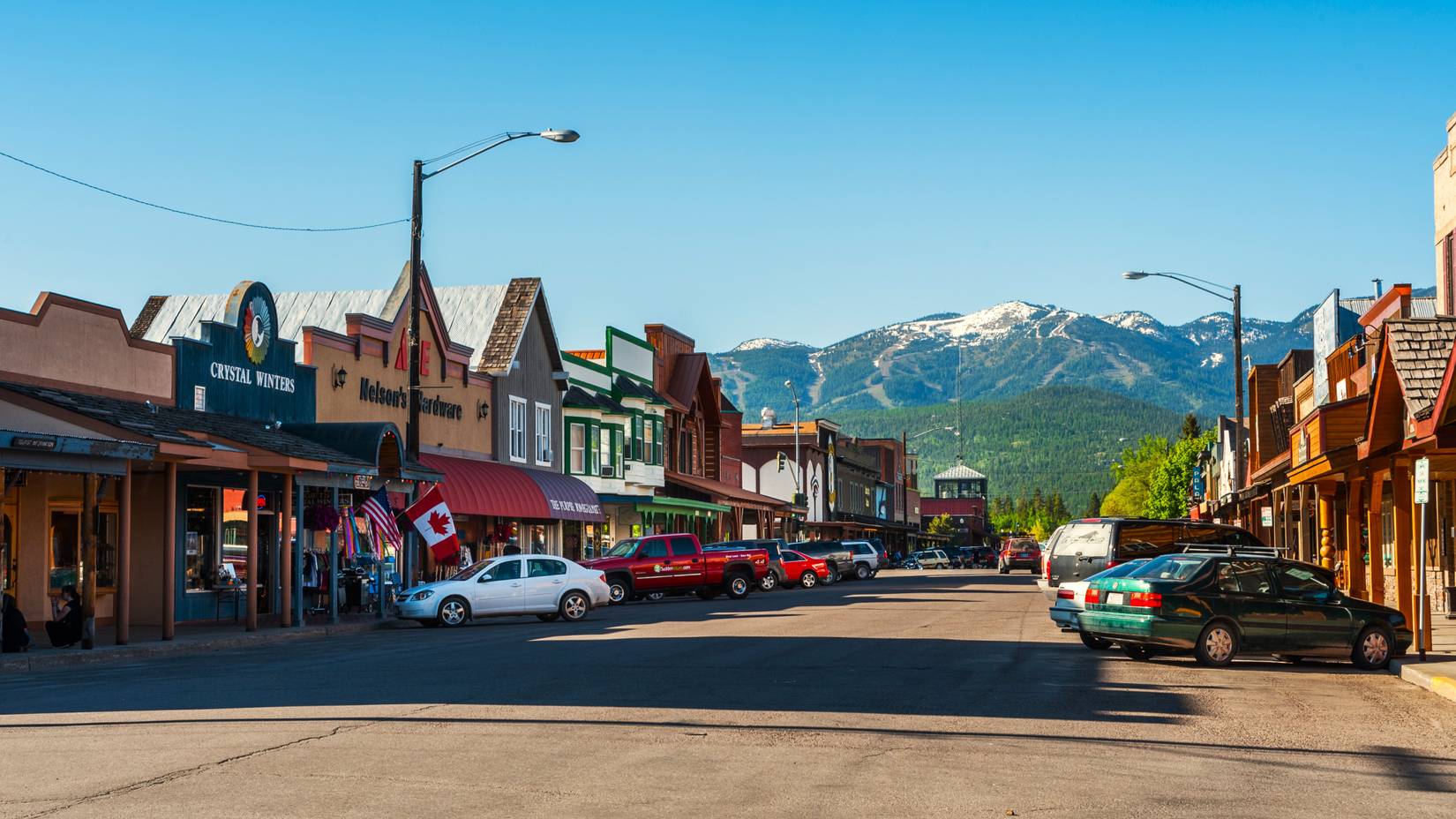 A view of Whitefish, Montana's main street, with snow-capped mountains in the background.