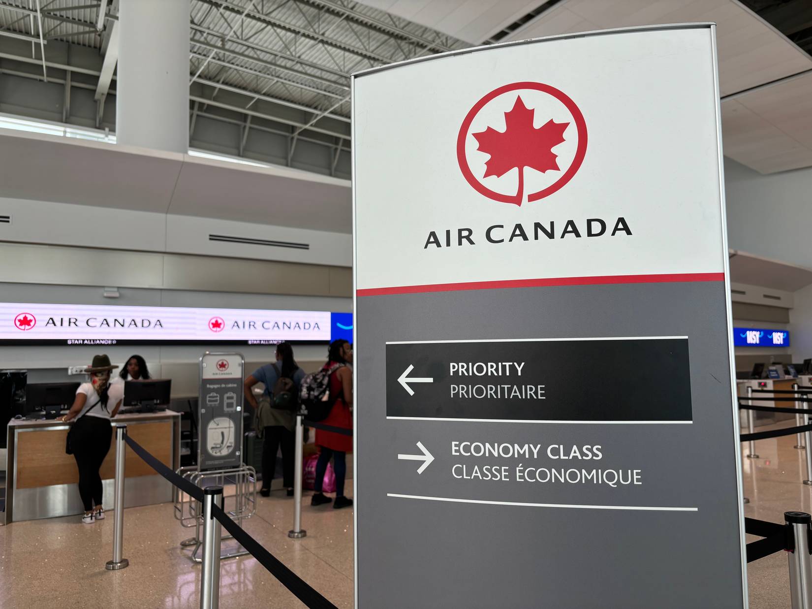Air Canada sign directing passengers to queues for priority and economy class