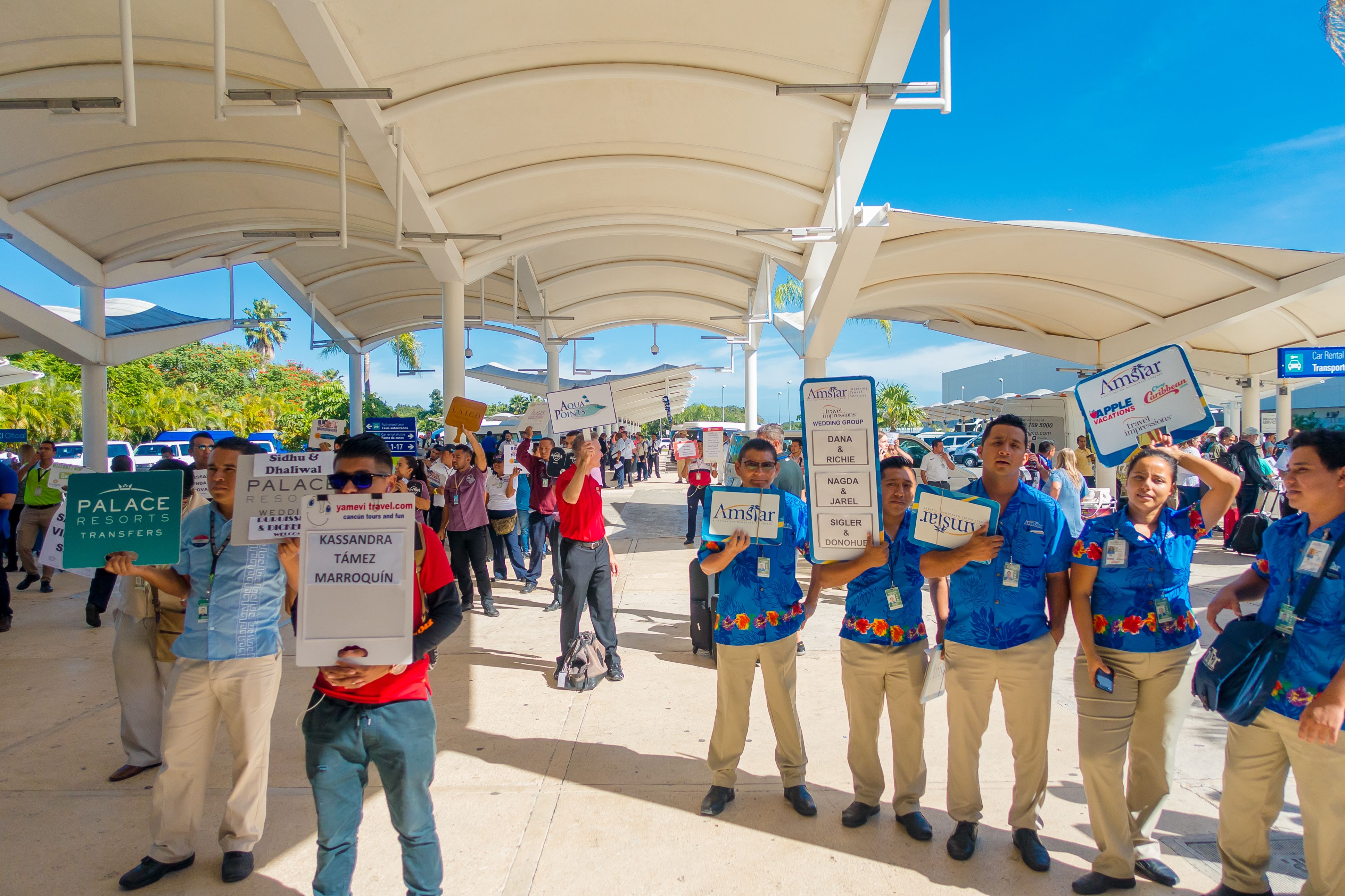 Unidentified people with signboards with names of tourists who arrived at the airport in Cancun