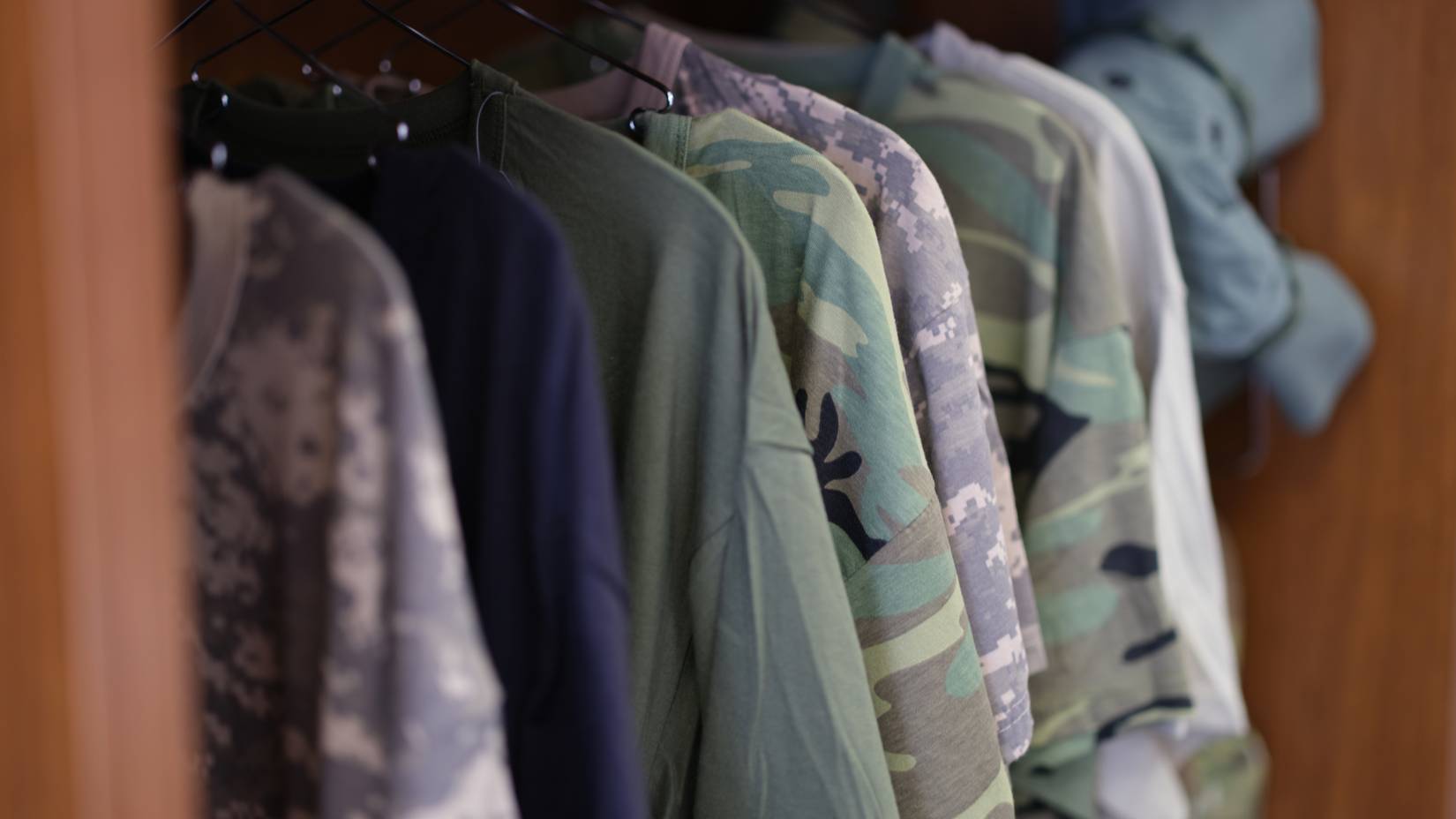 Camouflage shirts hanging in a closet