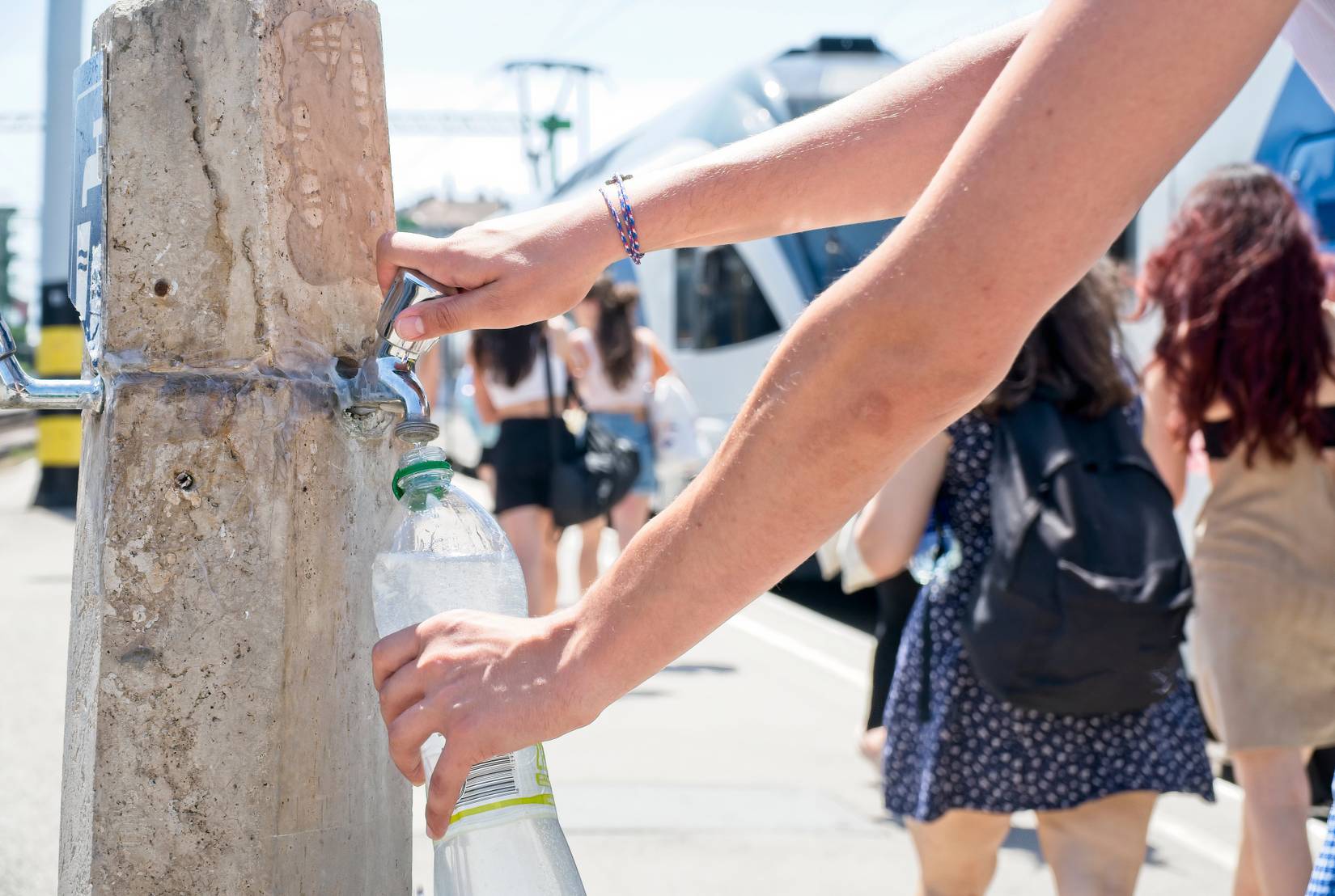 Man refilling his water bottle in the summer heat in Budapest, Hungary.