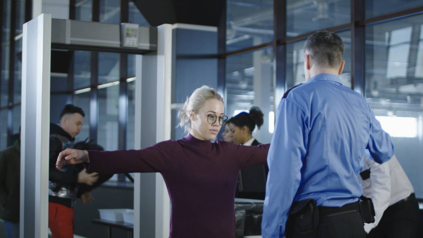 A woman being scanned at TSA at an airport
