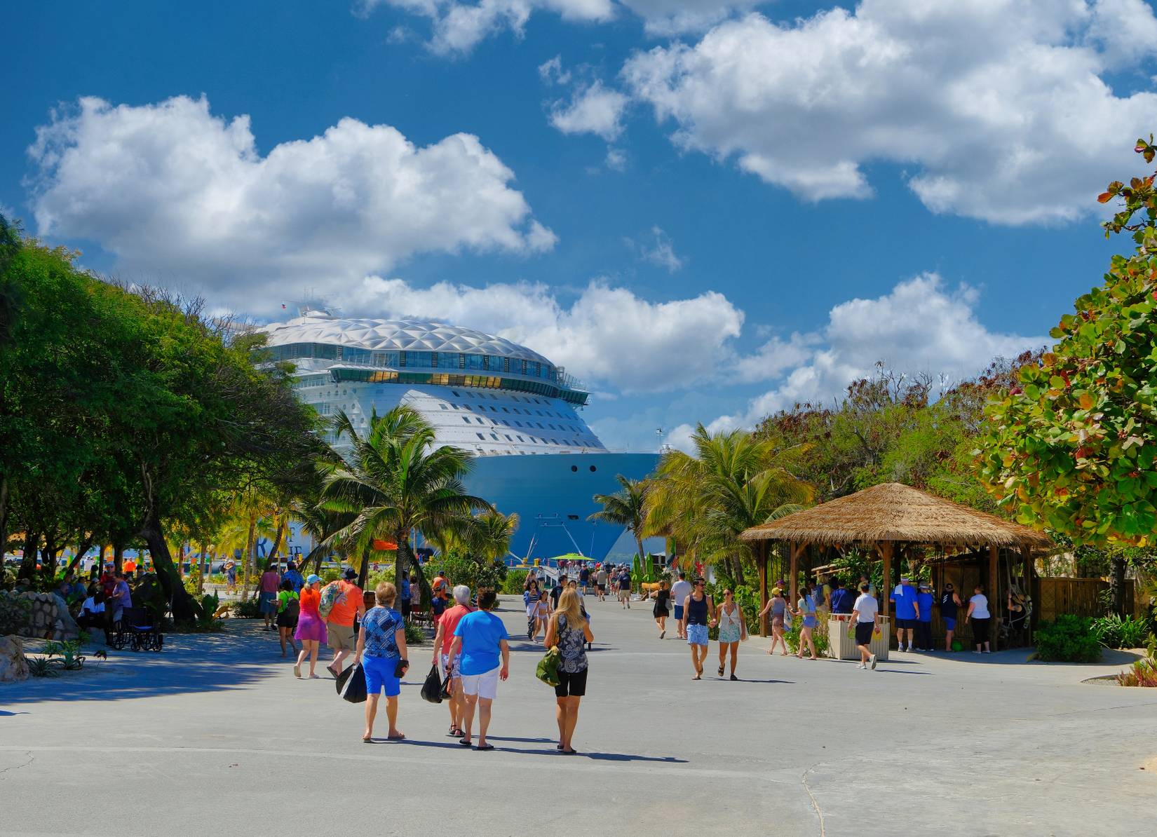 Cruise passengers walking toward Wonder of the Seas while docked in Labadee, Haiti.