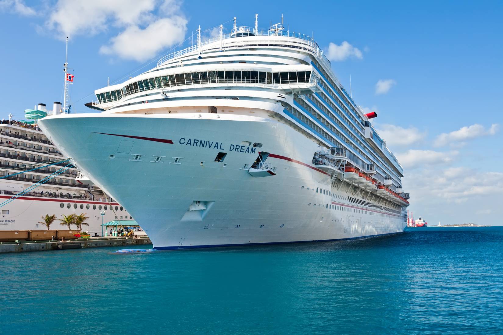 Carnival Dream cruise ship docked in the blue waters of Nassau, Bahamas