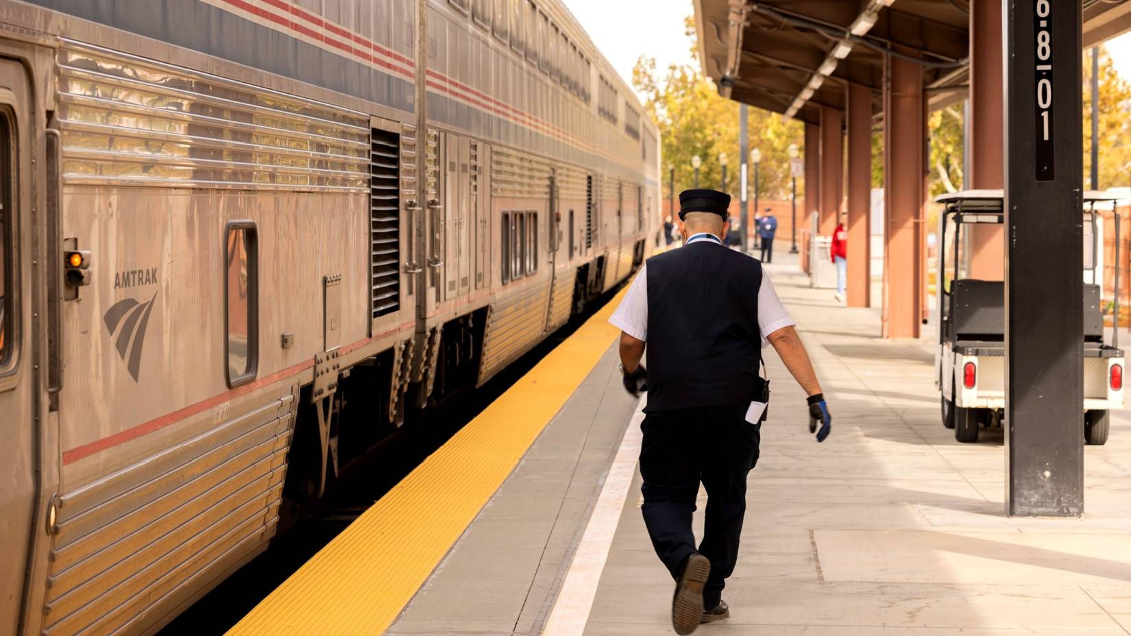 Amtrak conductor walking alongside a train on a platform at the Amtrak Diridon San Jose Station