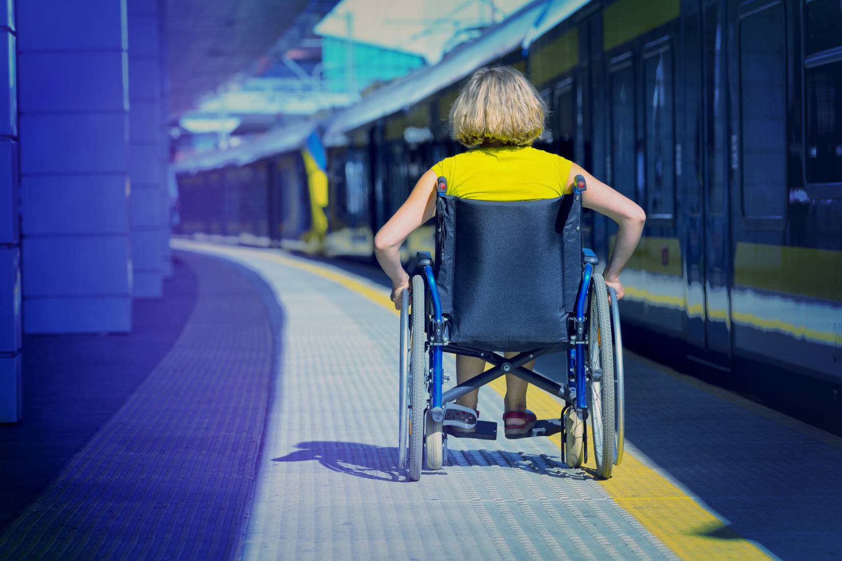 Woman in wheelchair on a train platform