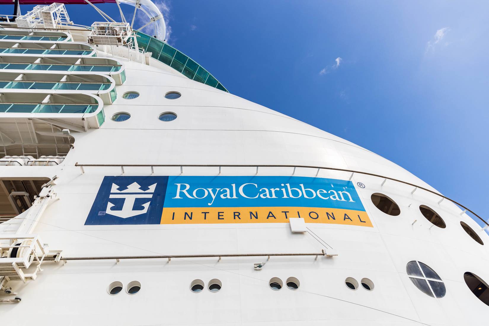 The side and logo of a white Royal Caribbean Navigator of the Seas ship