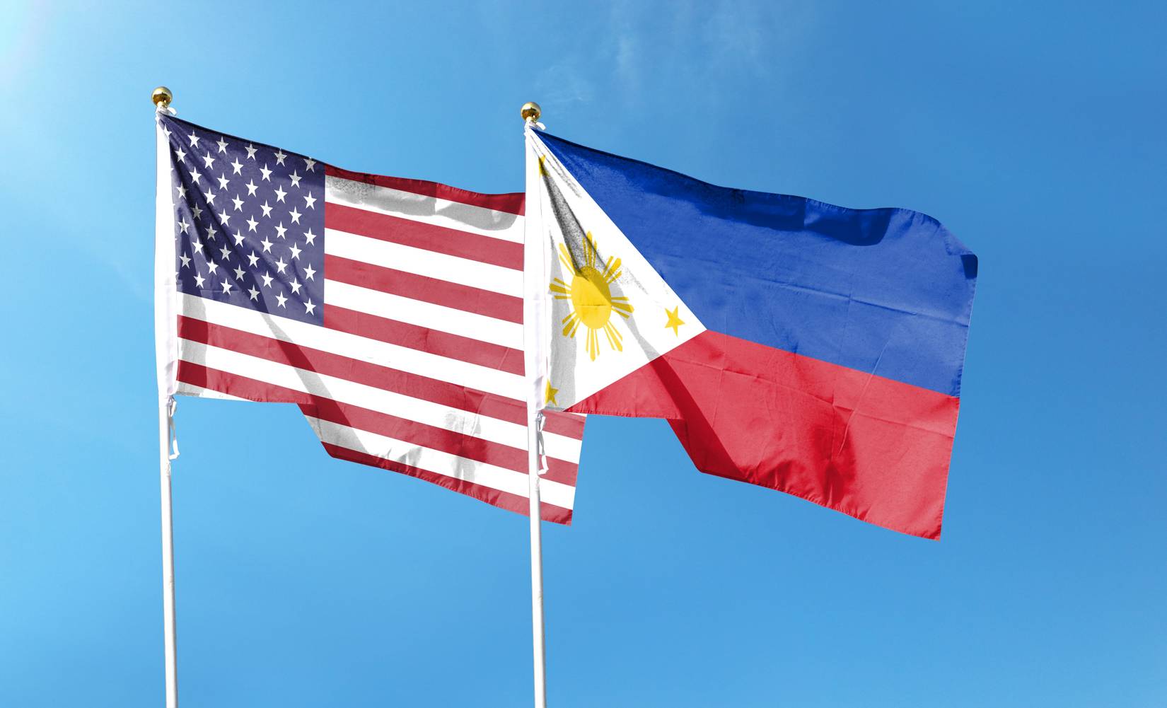 The American flag and the Philippine flag waving in the sky