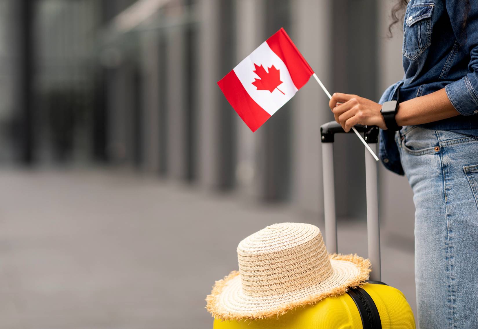 Traveler holding flag of Canada, going on vacation