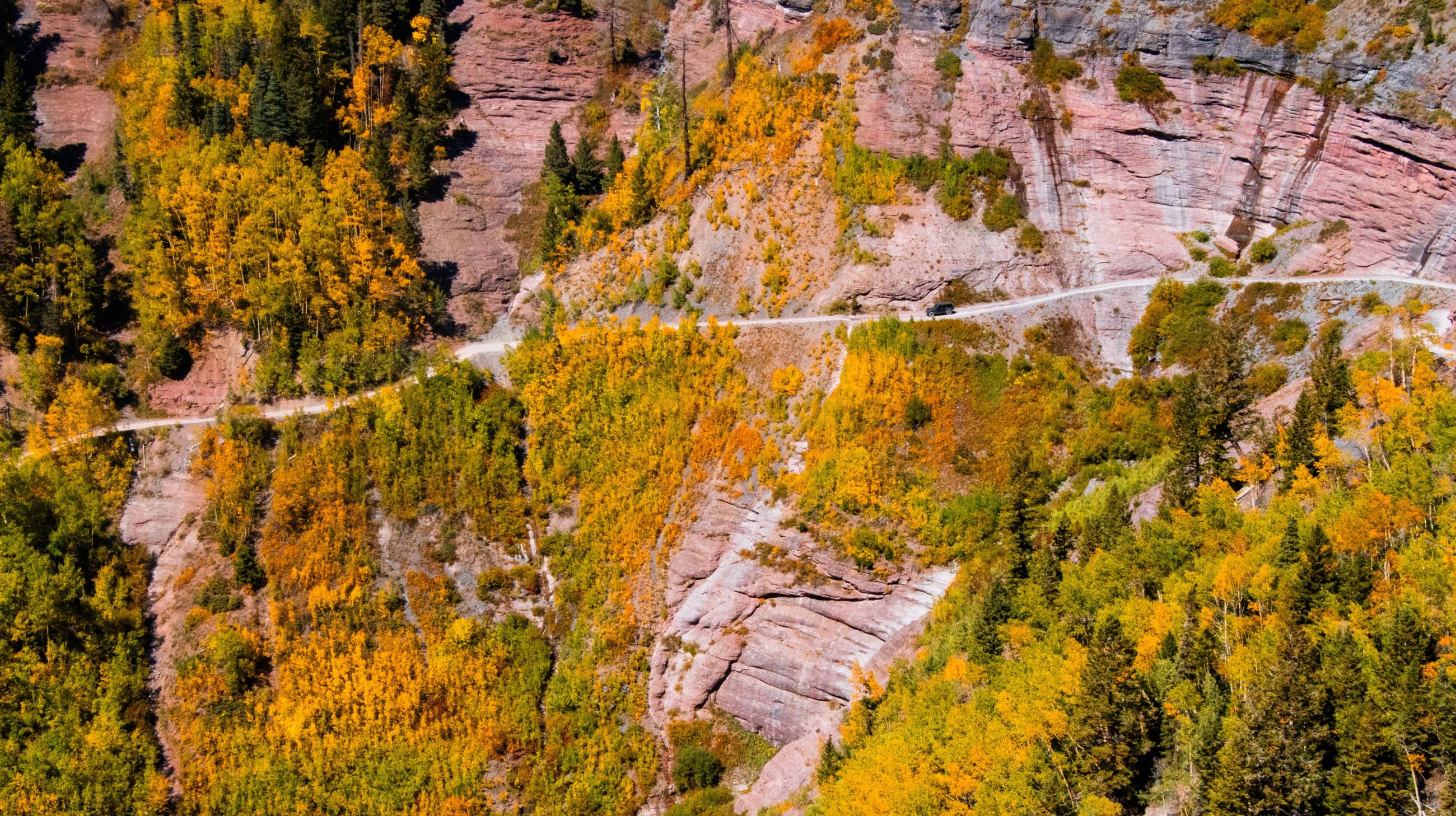 View of a Jeep driving along the side of Imogene Pass near Ouray, Colorado