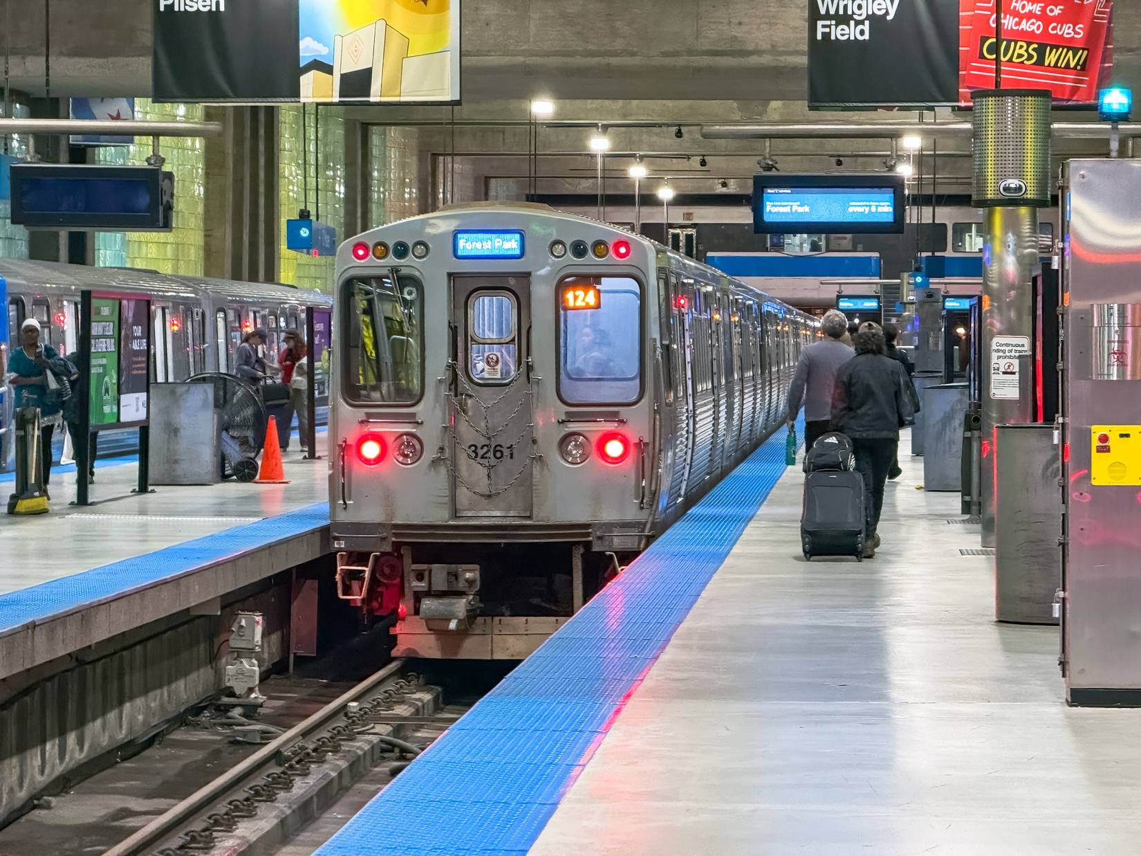 A train at Chicago train station in Illinois. Travelers with luggage board the train. 