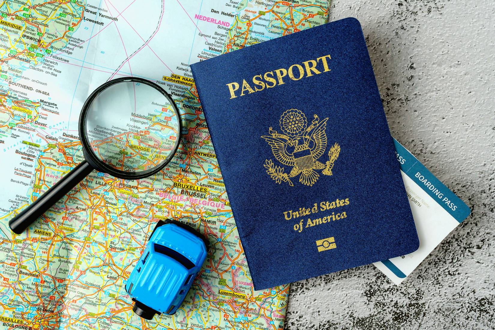 US passport on a map of the world and a magnifying glass