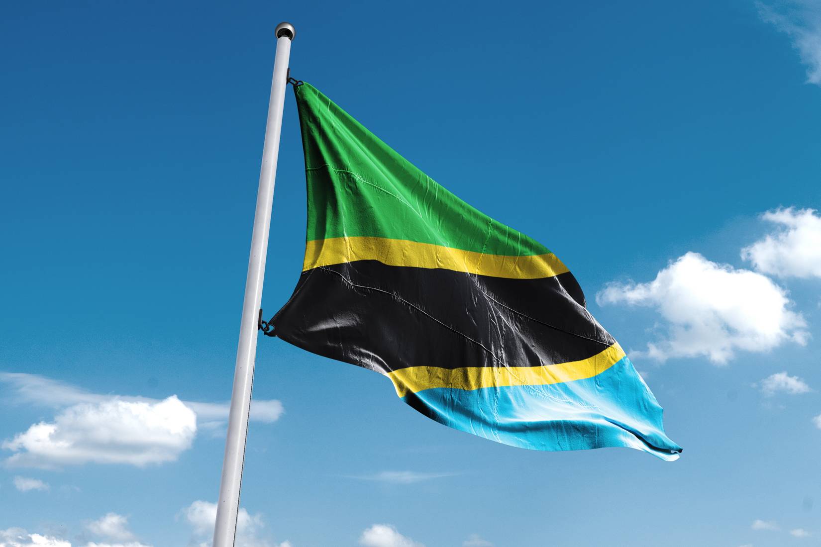 Waving flag of Tanzania in blue sky.