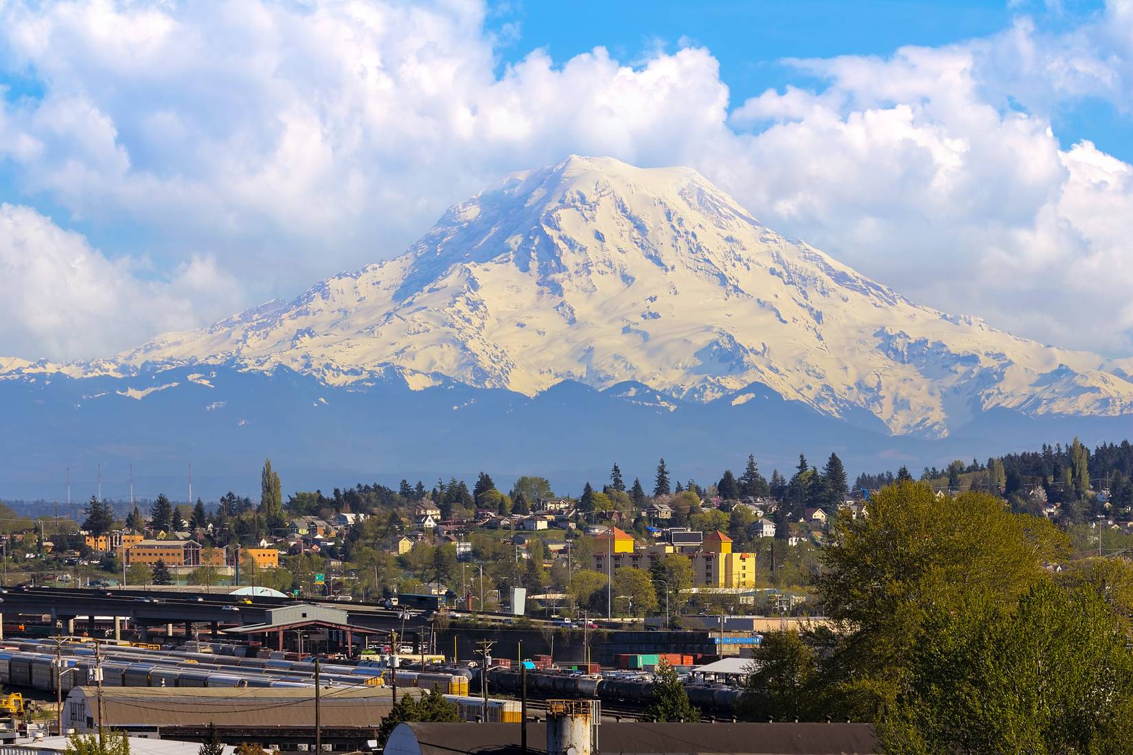 View of Mount Rainier over the Port of Tacoma, Washington industrial area and I-5 Interstate freeway, WA, USA.