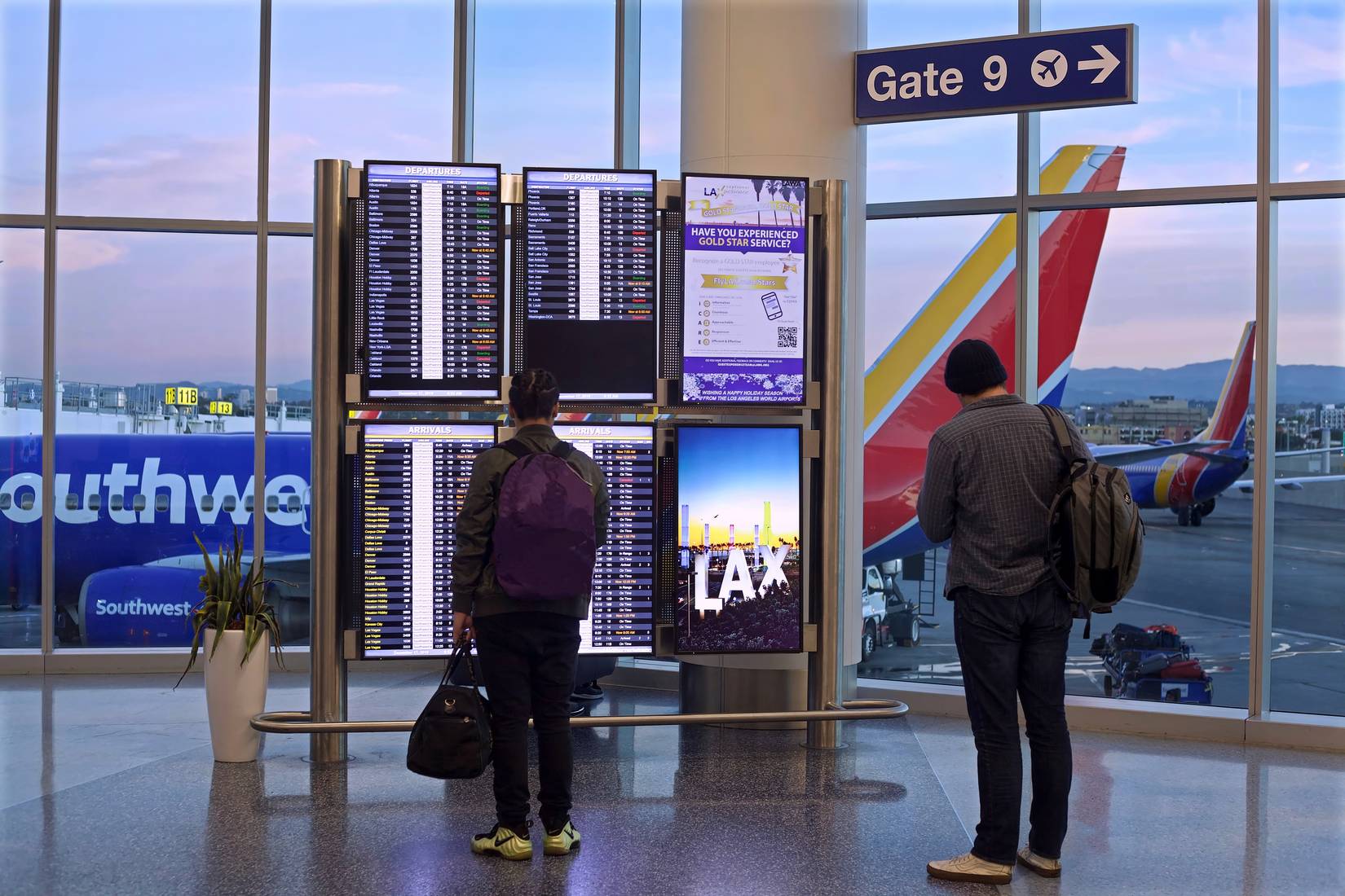 Southwest Airlines passengers view flight information display at Los Angeles International Airport