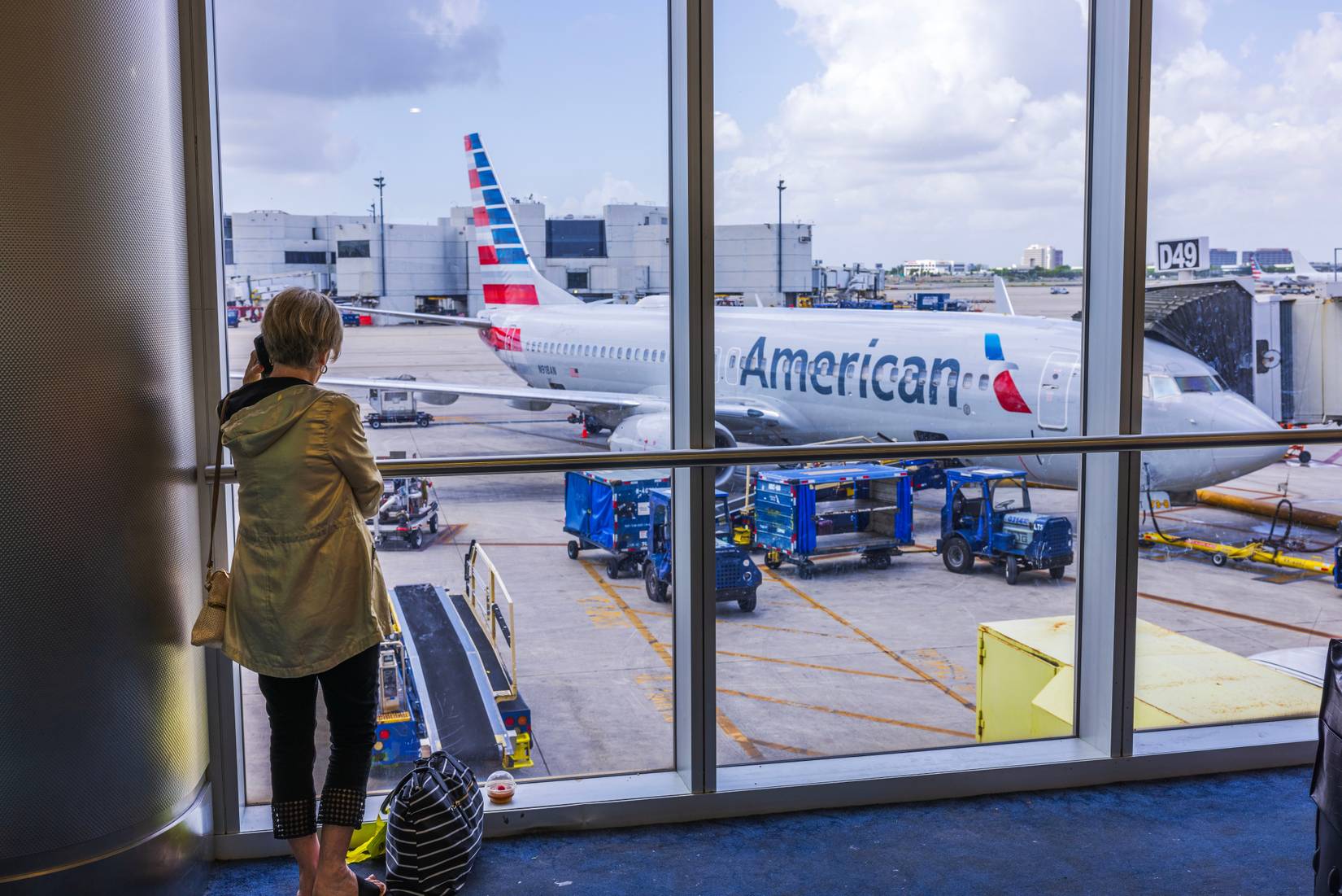 Woman at an airport in front of an American Airlines plane
