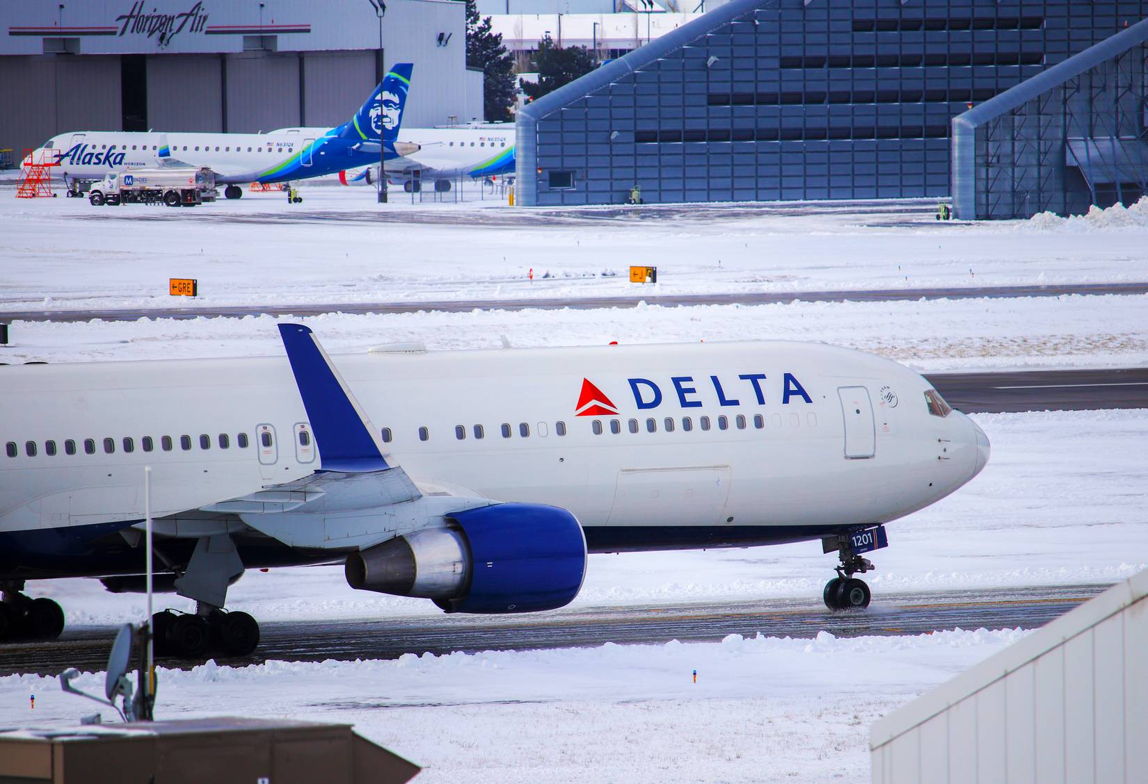 Delta Air Lines aircraft on a runway in winter covered in snow at a U.S. airport