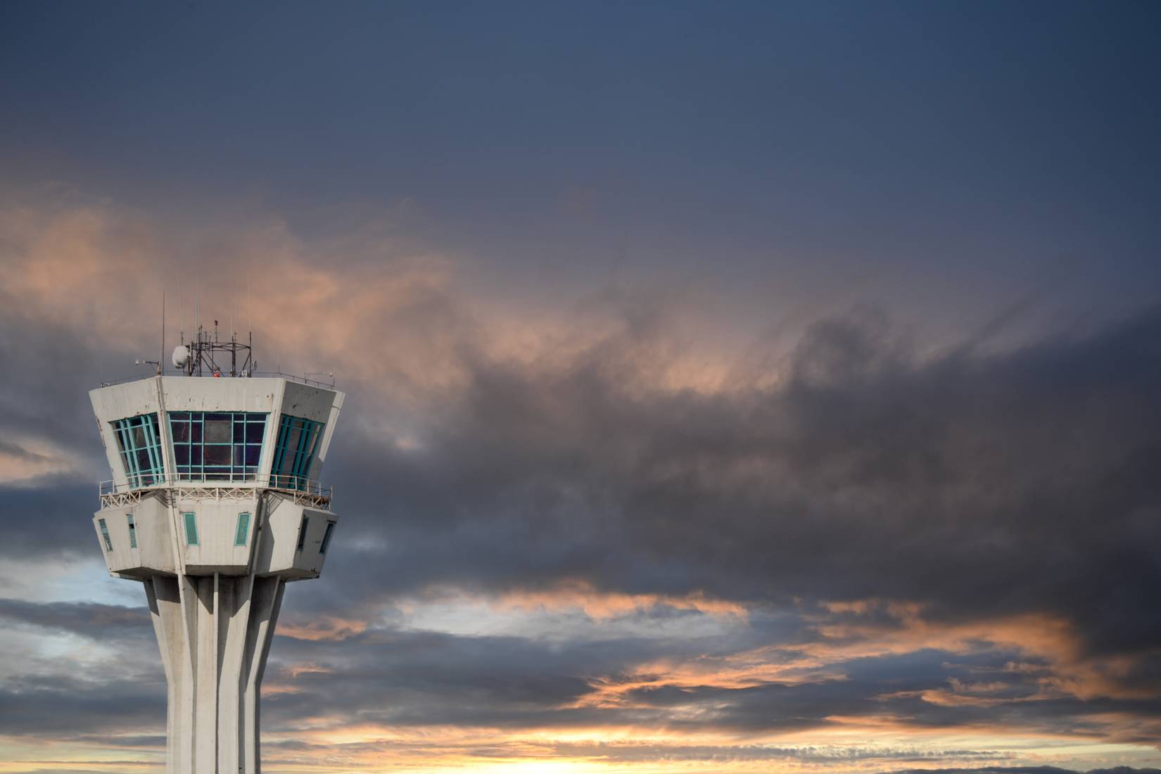 An air traffic control tower against a cloudy sky