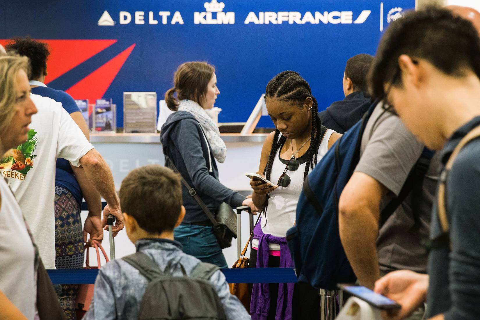 Passengers at a Delta Air Lines check-in desk at an airport