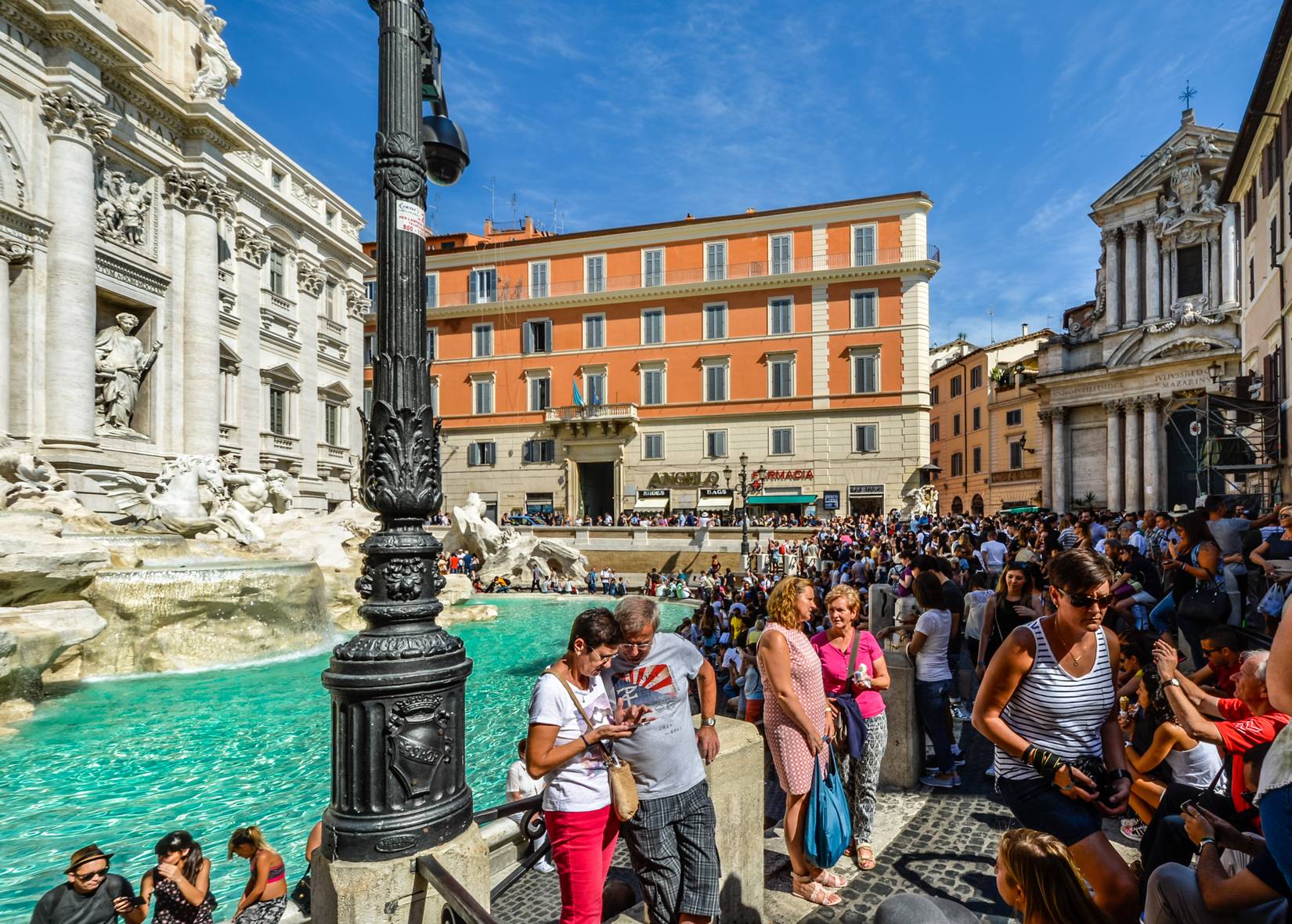 A large crowd of tourists visiting the Trevi Fountain