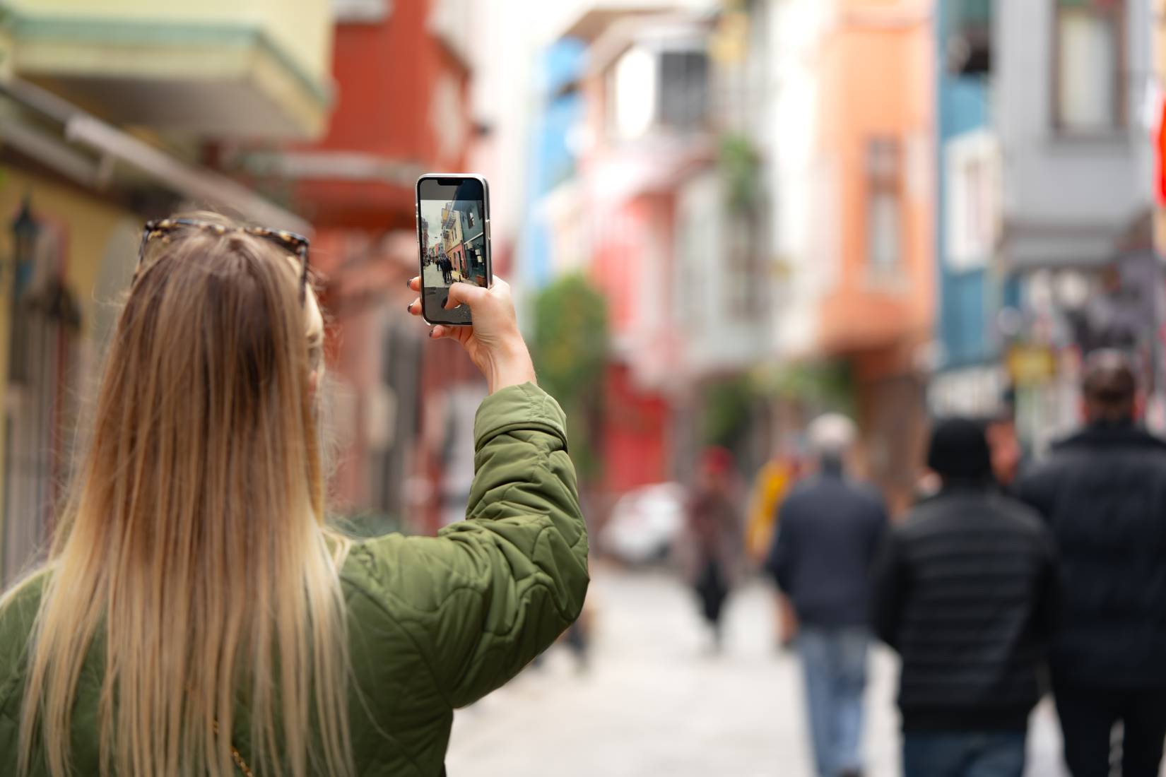 A traveler taking a photo with her phone camera