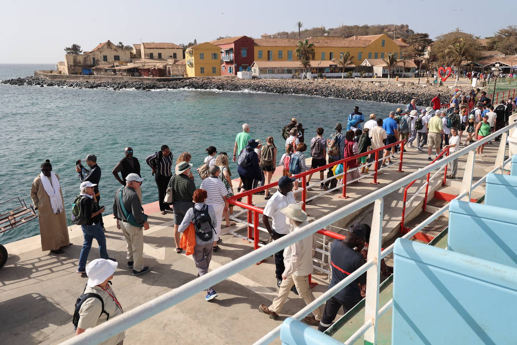 Outdoor scene of passengers debarking from the boat linking Dakar to Goree, heading to a small beach