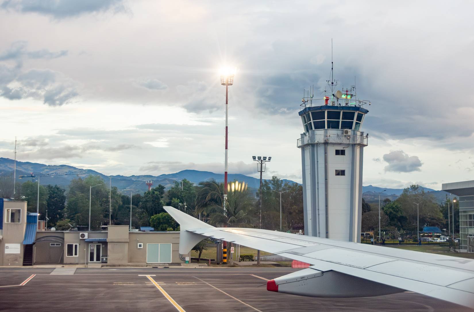 Scenic view from an airplane wing showcasing the airport control tower and surrounding landscape in Popayán, Cauca, Colombia