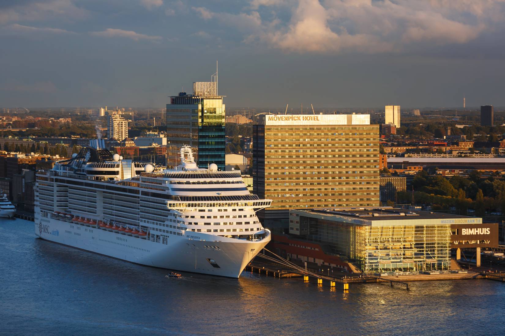 MSC Preziosa docked in Amsterdam, Netherlands at sunset