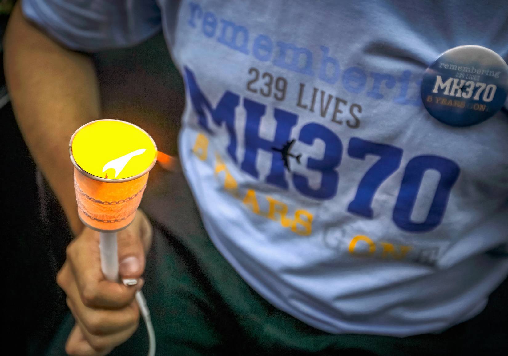 一名男子在马航 MH370 航班失踪五周年纪念仪式上举着烛光