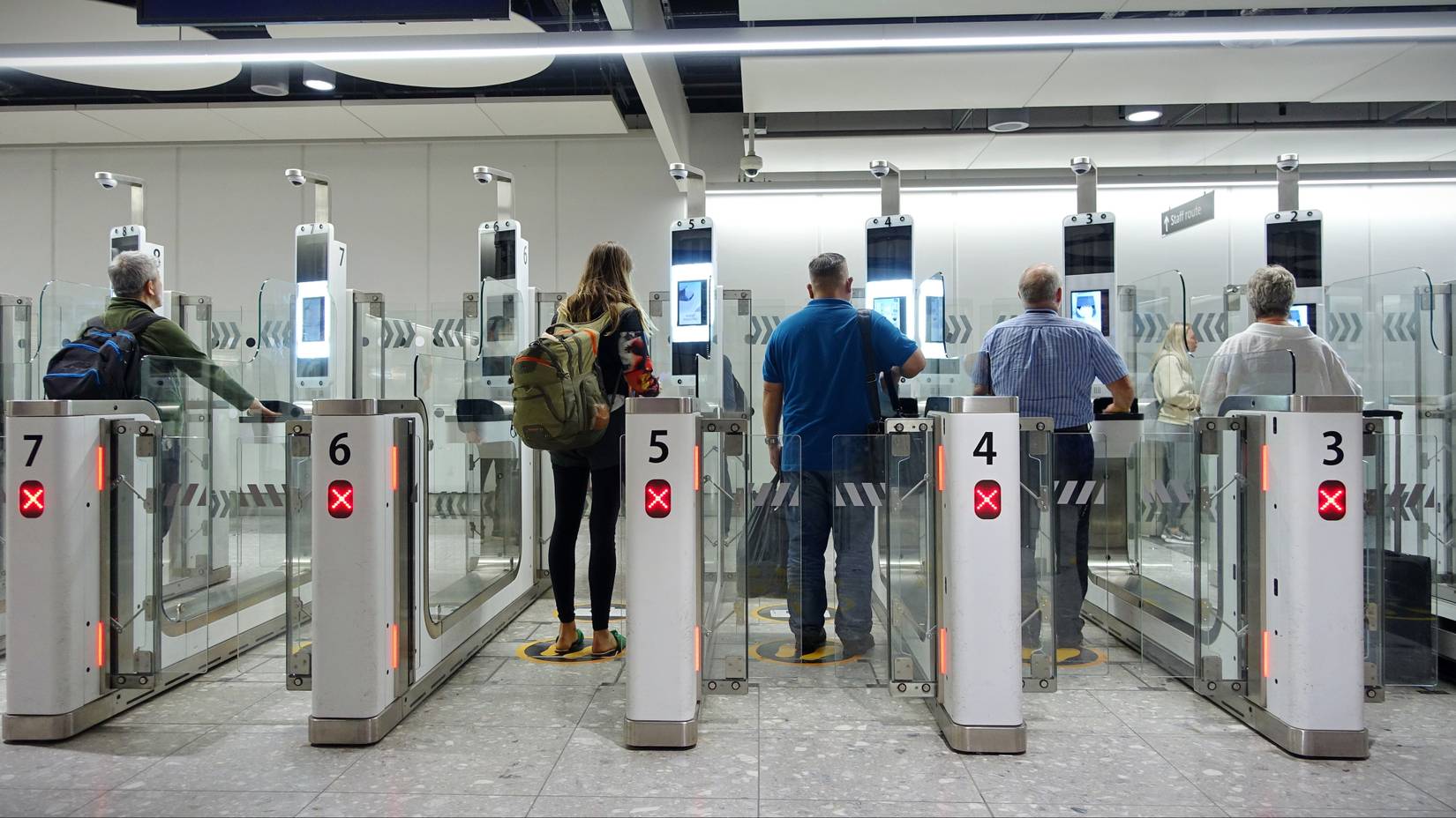 Air travelers passing through the automated passport border control gates at Heathrow Airport in the UK. The UK now requires visitors to apply for an Electronic Travel Authorisation (ETA).
