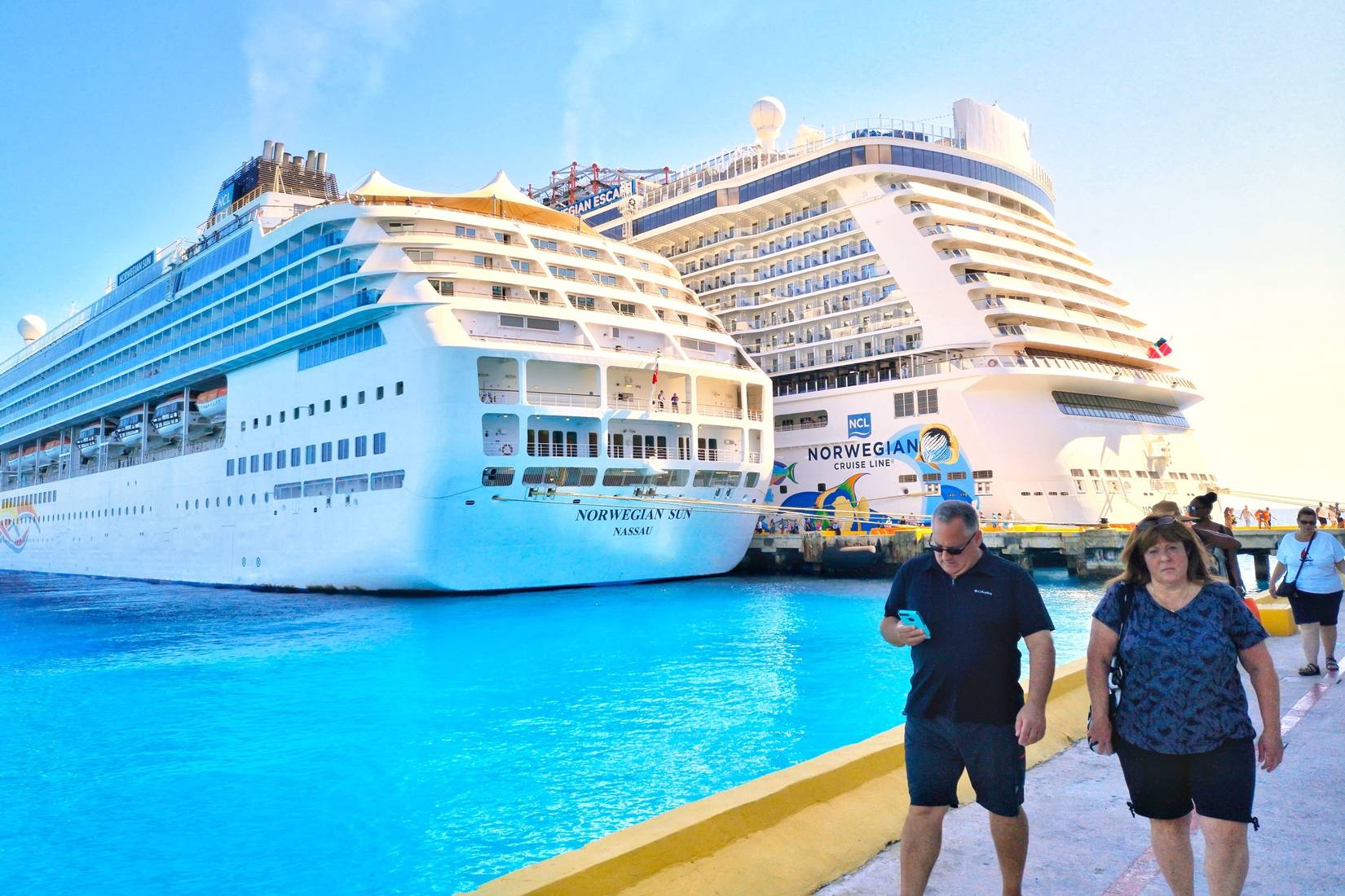 Norwegian Cruise Line ships docked in Costa Maya, Mexico. Passengers walking along the dock.