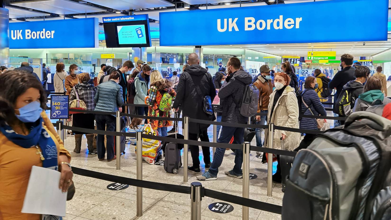 Air travelers queuing at border control in Heathrow Airport, UK, who are required to apply for an Electronic Travel Authorisation (ETA).