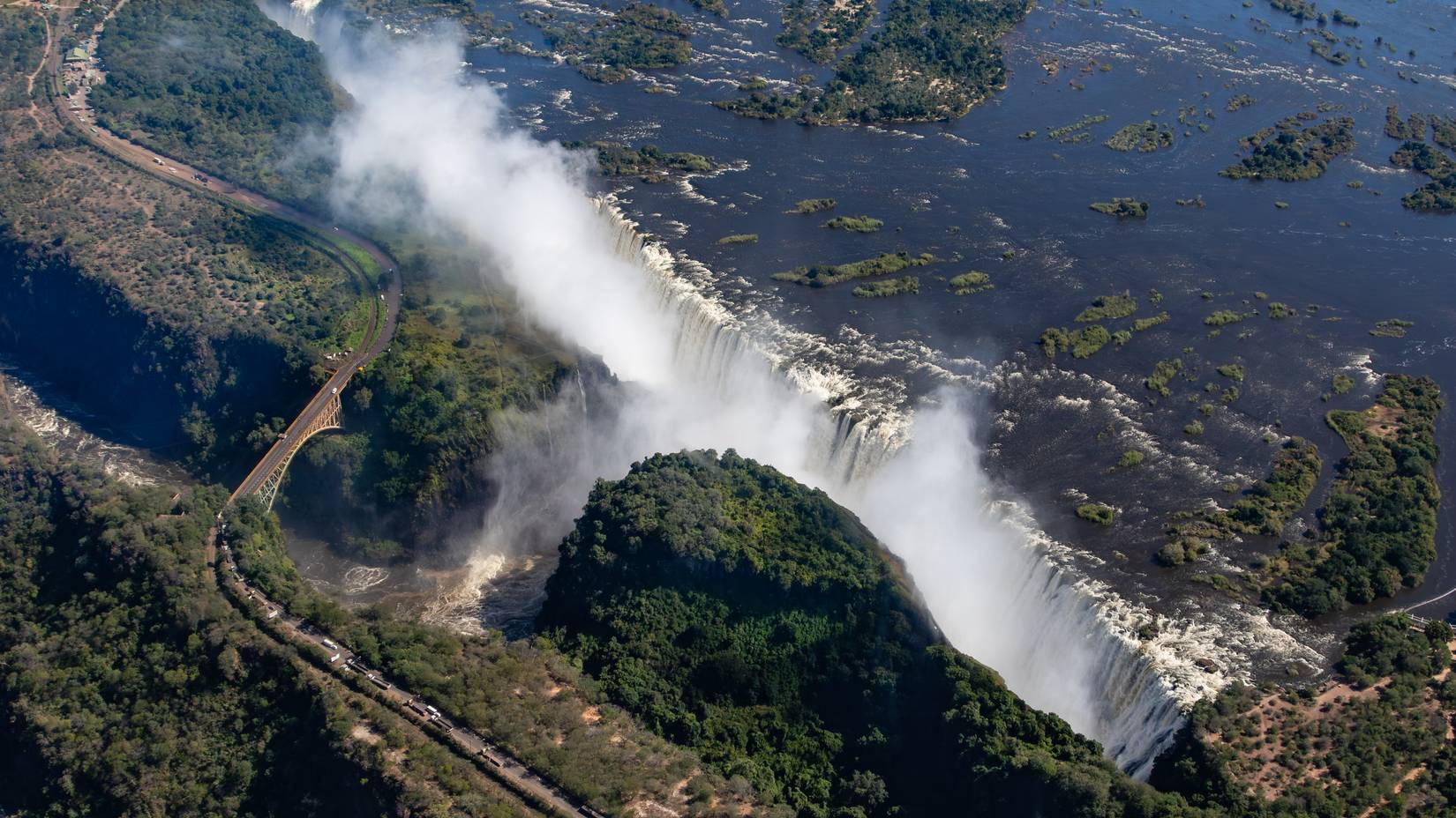 An aerial view of the Zambezi in flood at the Victoria fall with the road and bridge between Zimbabwe and Zambia