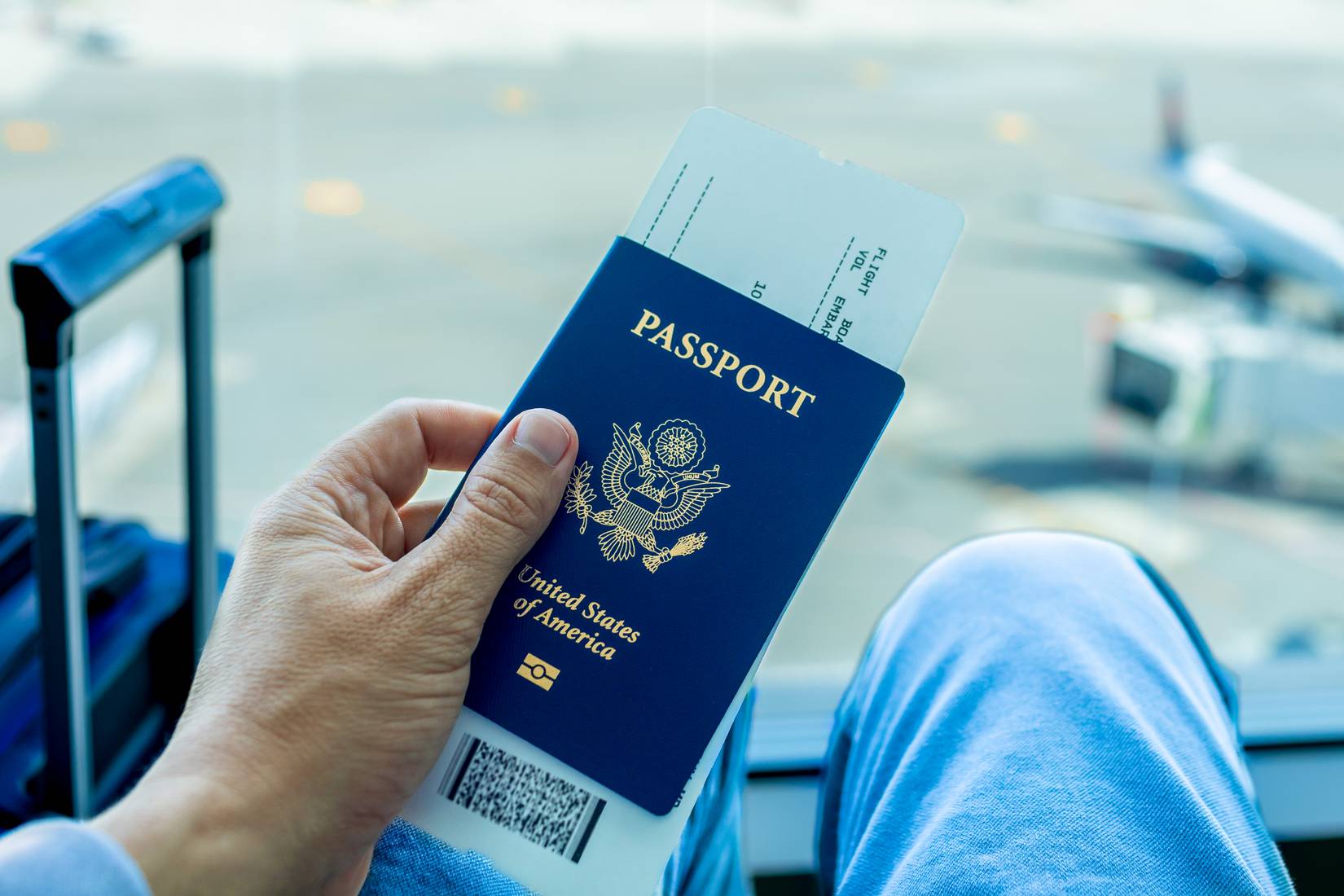 Traveler with US passport and a boarding pass in between its pages