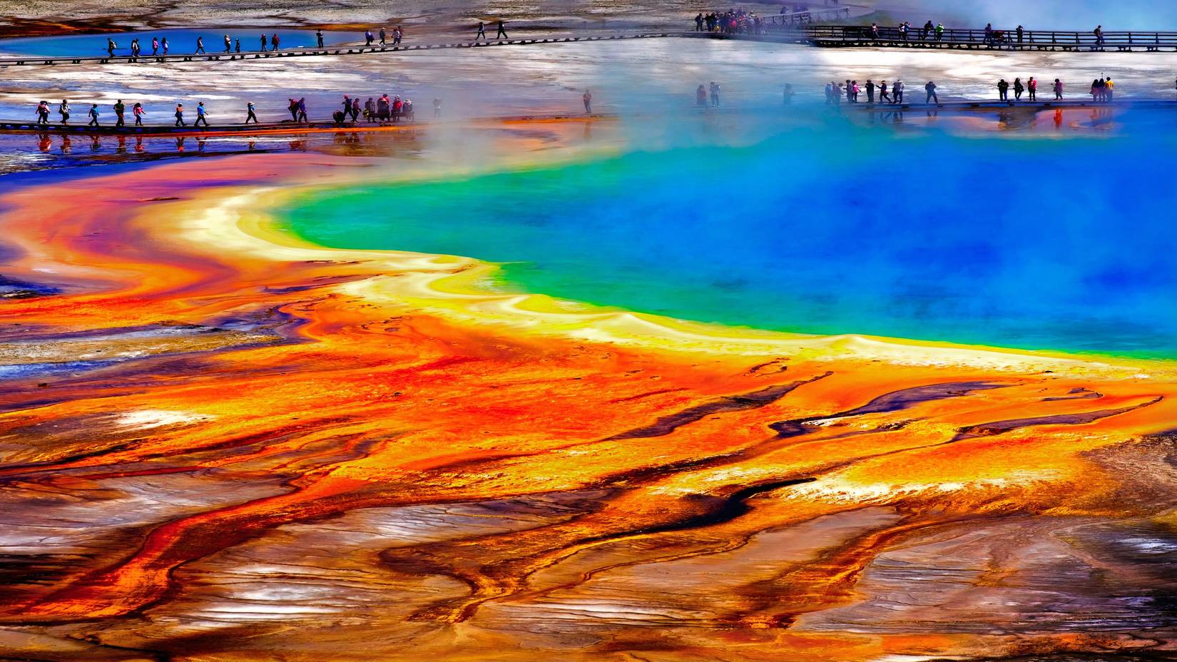 Grand Prismatic Spring in Yellowstone National Park, with tourists viewing the spectacular natural scene
