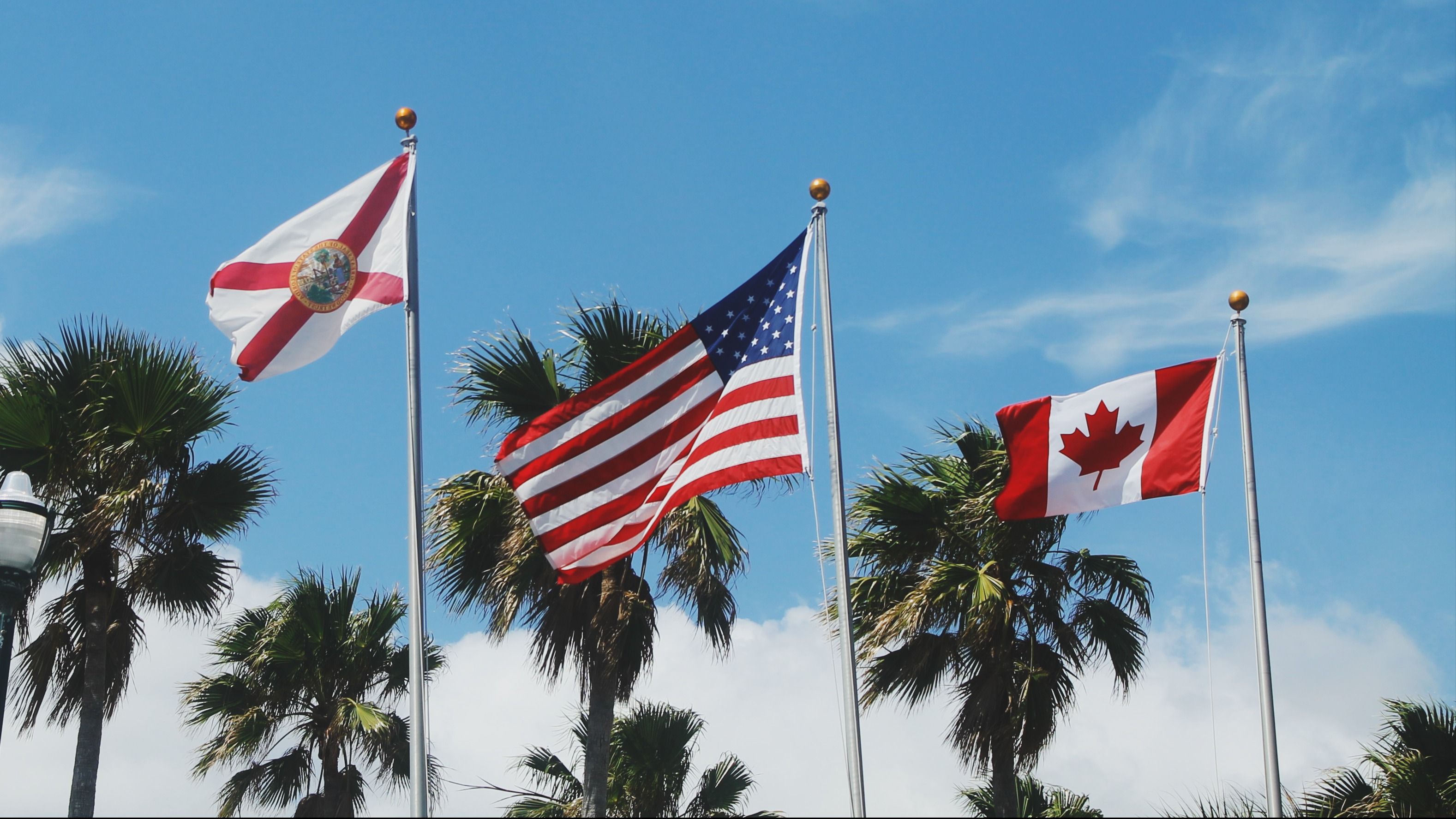 The flags of the State of Florida, the U.S., and Canada waving in the sky