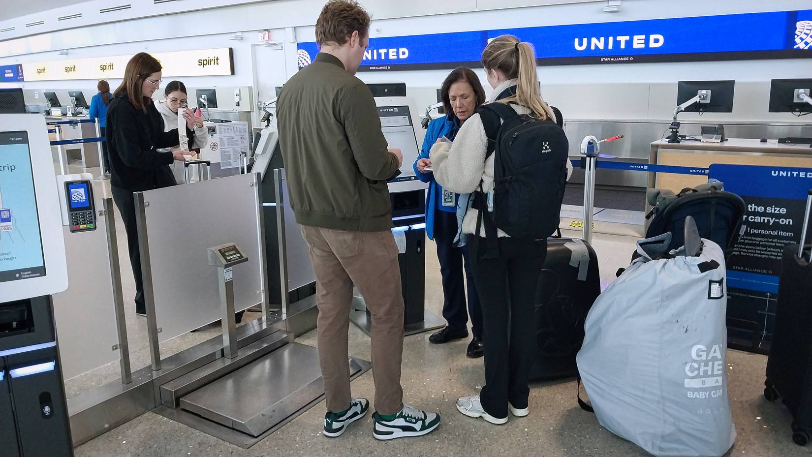 Passengers at a United Airlines check-in desk at an airport