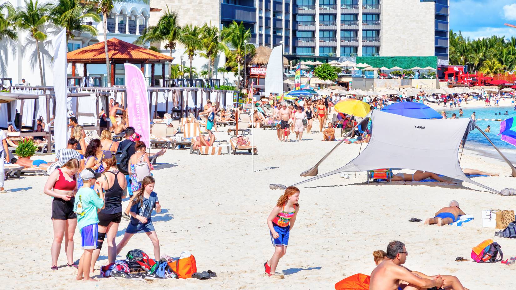 Crowded beach filled with people in Riviera Maya on the Caribbean coast of Cancun, Mexico