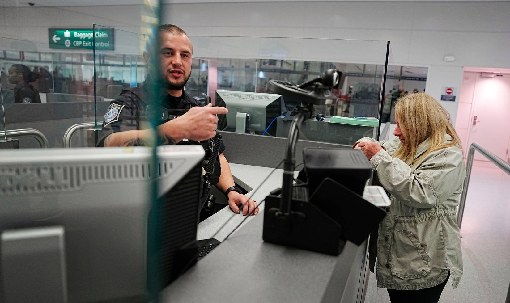 A U.S. Customs and Border Protection (CBP) officer conducting passport checks at a U.S. airport