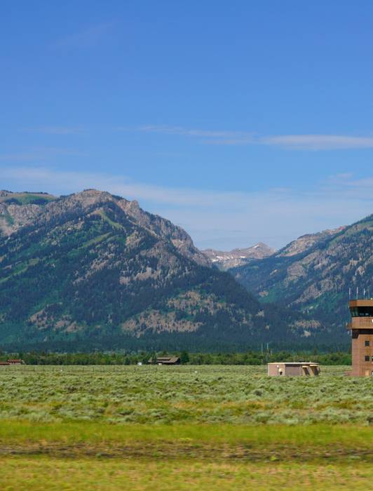 View of the air traffic control tower at the Jackson Hole Airport (JAC) in Jackson Hole, Grand Teton National Park, Wyoming. Mountains can be seen in the background.