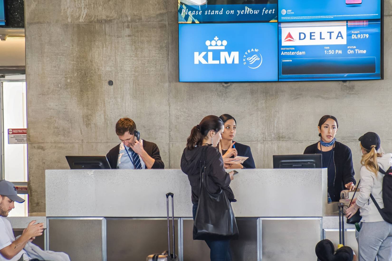 Passengers at a KLM and Delta Air Lines counter at an airport