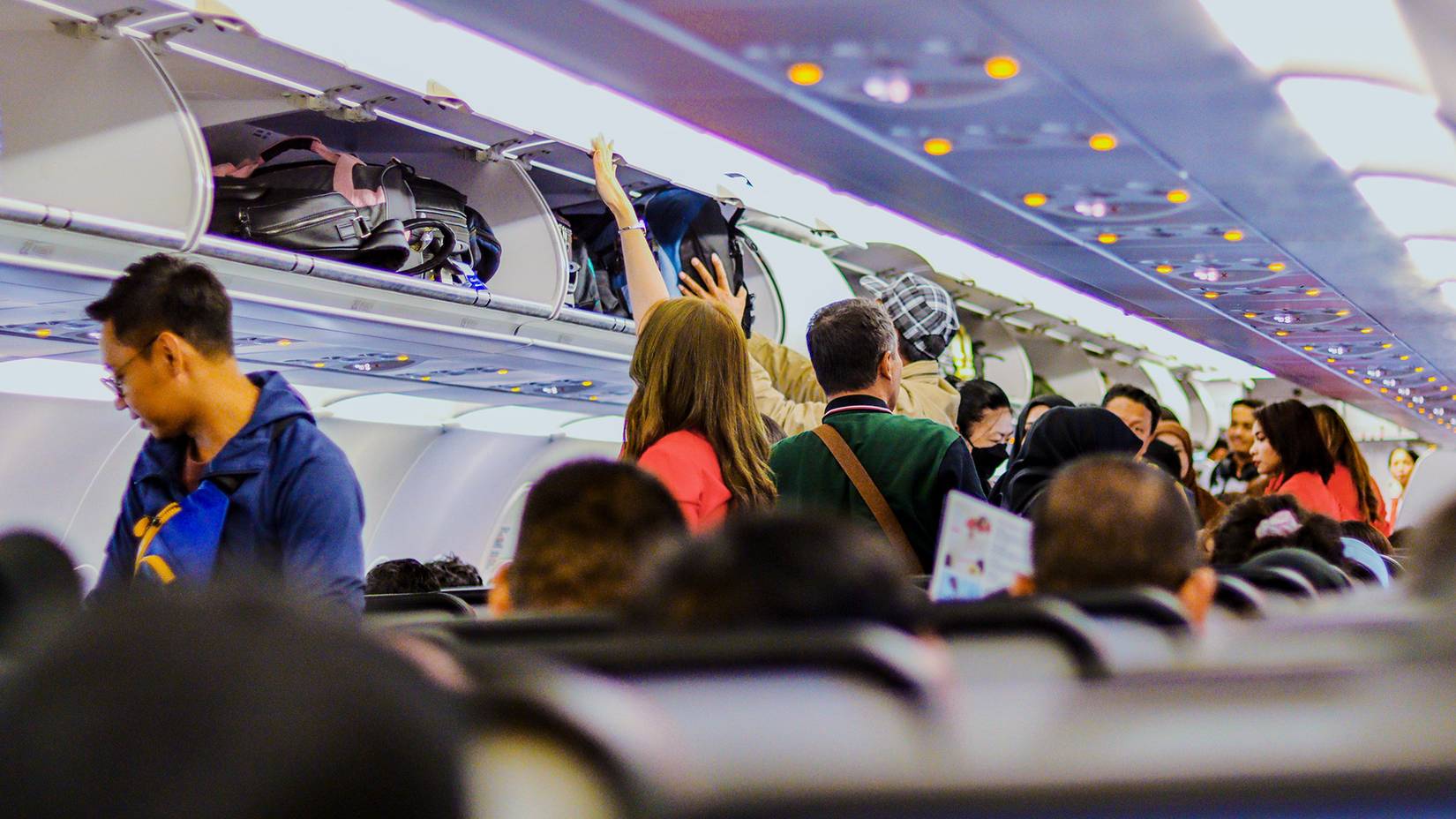 Passengers Stowing Carry On Luggage