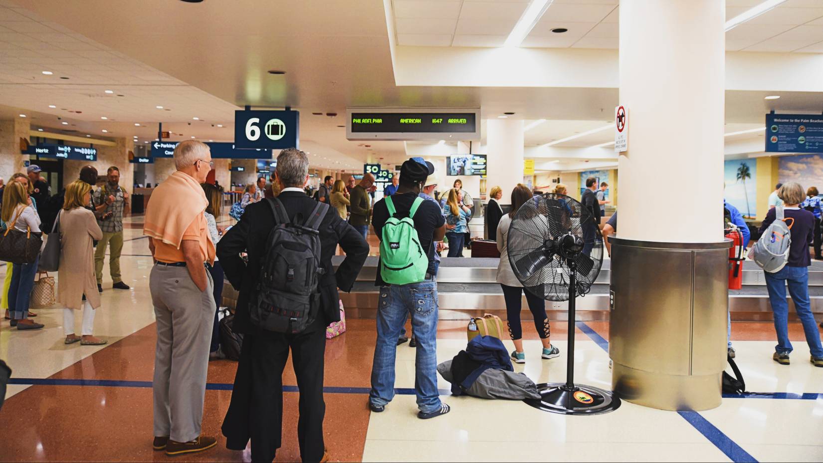 Passengers wait to collect their baggage from a luggage carousel at formerly named Palm Beach International Airport (PBI), now called Donald J. Trump International Airport (DJT)
