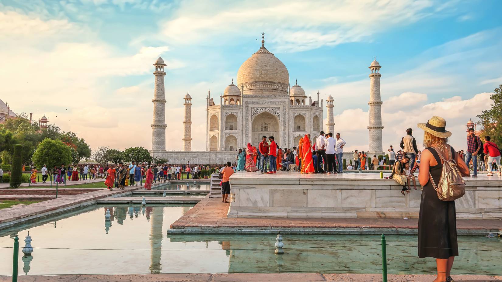 View of female tourist enjoying the view of the Taj Mahal at sunset in Agra, India