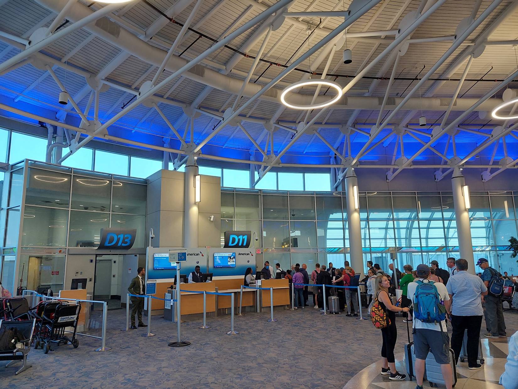 American Airlines passengers waiting as crew boards the flight.